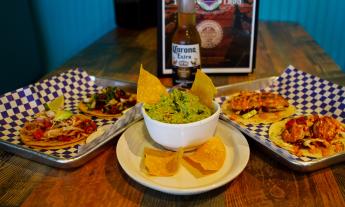 A spread of tacos with chips and guacamole