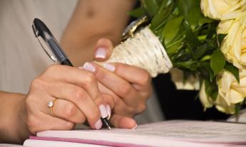 A bride signing the marriage record. (Photo courtesy of Pixabay.)
