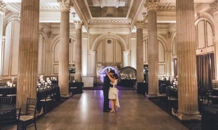 A bridal couple, alone in the venue, dancing