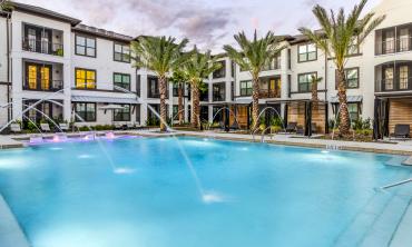 Brisa Apartments and the pool and pool deck, with palm trees and fountains