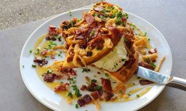 A plated chicken and waffles decorated with additional toppings