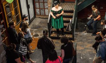 A guide telling ghost stories in an alley