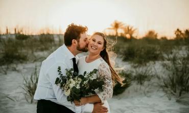 A bride and groom, delighted after their beach wedding at sunset